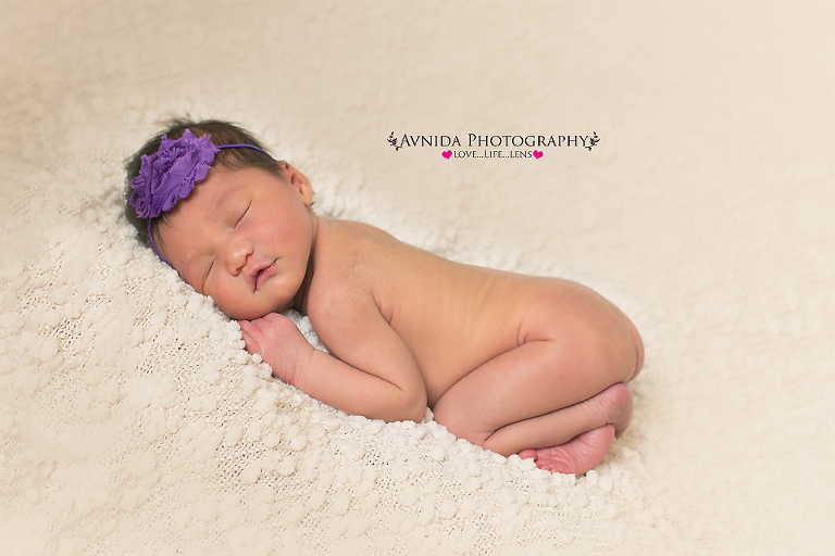 Karter with a purple flower headband in frisco newborn baby photographer