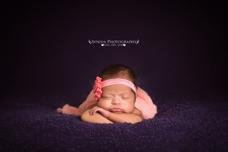 baby with hands under chin with cute pink flower headband in this Newborn Photography Metuchen New Jersey session