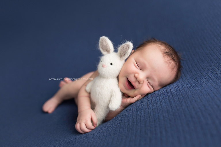 Newborn-baby-photography-smiling-with-lovie