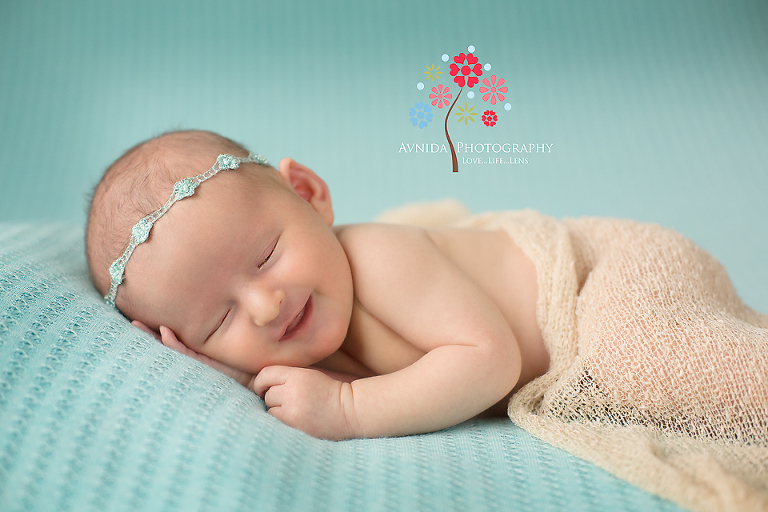 Newborn Photographer Hoboken New Jersey taking pictures of the smiling baby