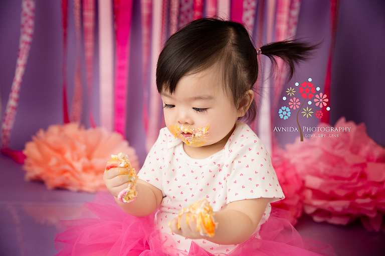 cake smash photos session and kailey looking at her hands