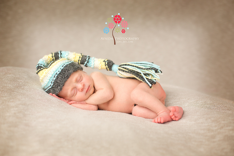 newborn photography green village sleeping in green cap by www.avnidaphotography.com