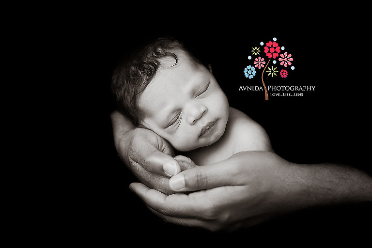 Picture of a cute newborn in daddy's arms from your Newborn Photographer Middletown NJ