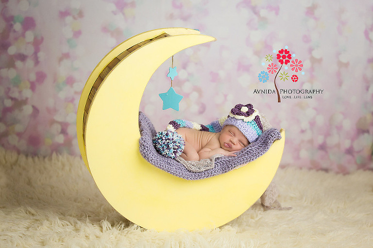 Picture of a cute newborn sleeping on a moon from your Newborn Photographer Middletown NJ by www.avnidaphotography.com