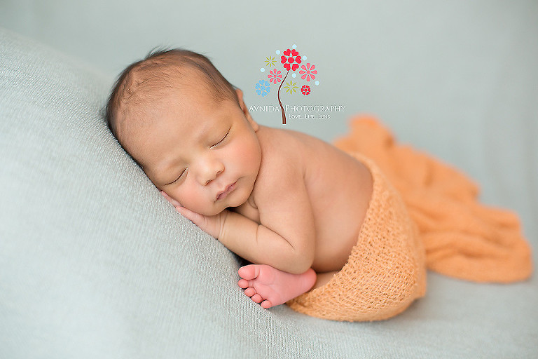 Zoe in orange wrap in green blanket in picture from Newborn Photography Ocean County NJ by www.avnidaphotography.com