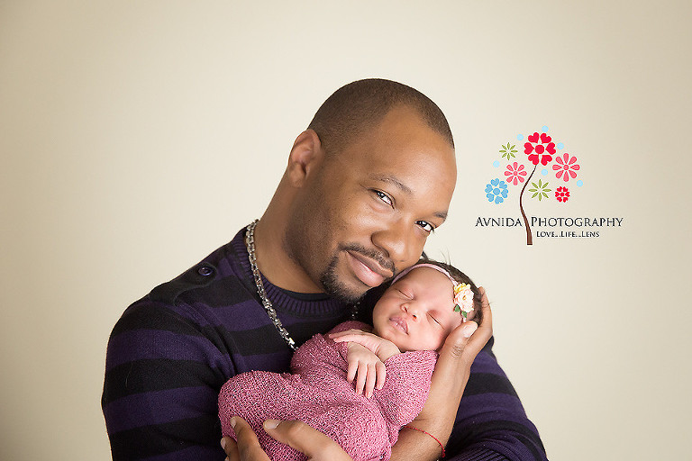 Picture of a cute newborn smiling with daddy from your Newborn Photographer Middletown NJ