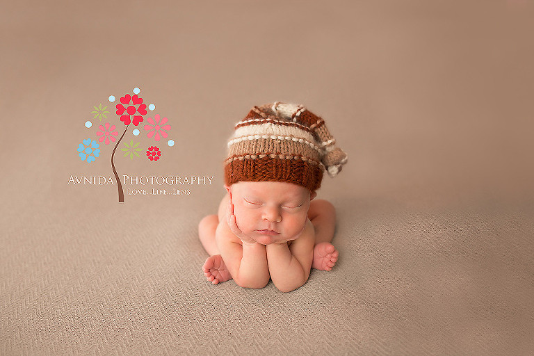 Newborn Photography Far Hills NJ - hands on chin pose with a different cap