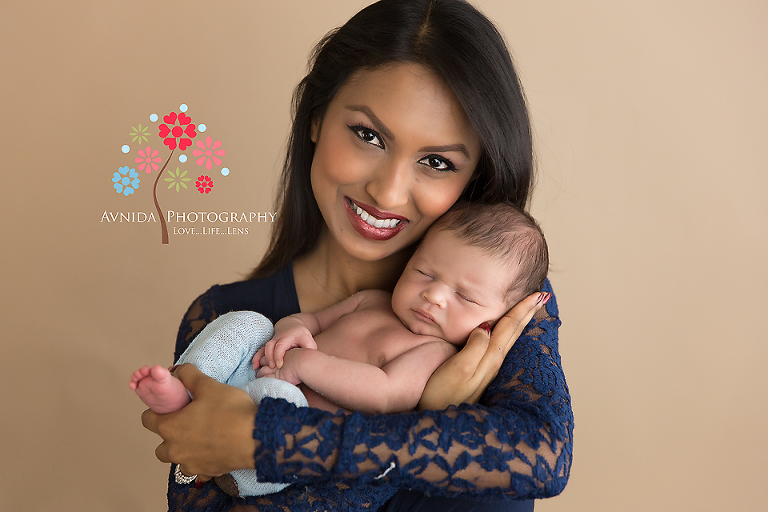 Mom is all smiles as she holds Nigel in her arms for the newborn baby photo shoot