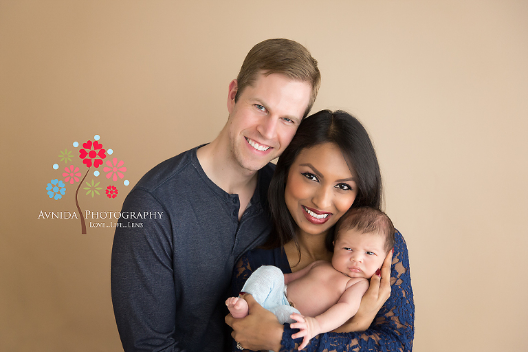 Nigel smiles with mom and dad for his newborn photo session