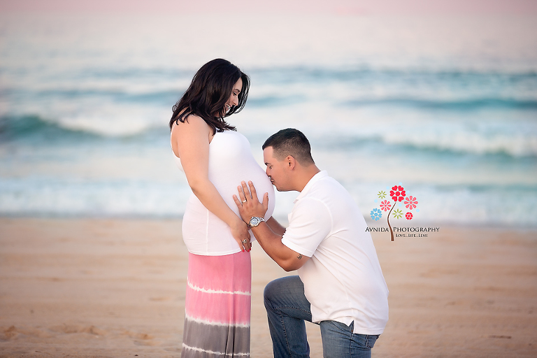 The little one in the tummy get a kiss from daddy. Beach Photography by Avnida Photography.