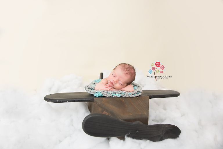 Newborn Photography New Brunswick NJ - Mr. Smooth goes for a ride on a plane. The sky is clear and he flies above the clouds.
