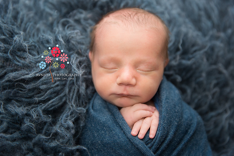 Newborn Photography Teaneck NJ - Those cute hands sticking out of the blue wrap, with the blue blanket in the back - It cannot get cuter than this, can it