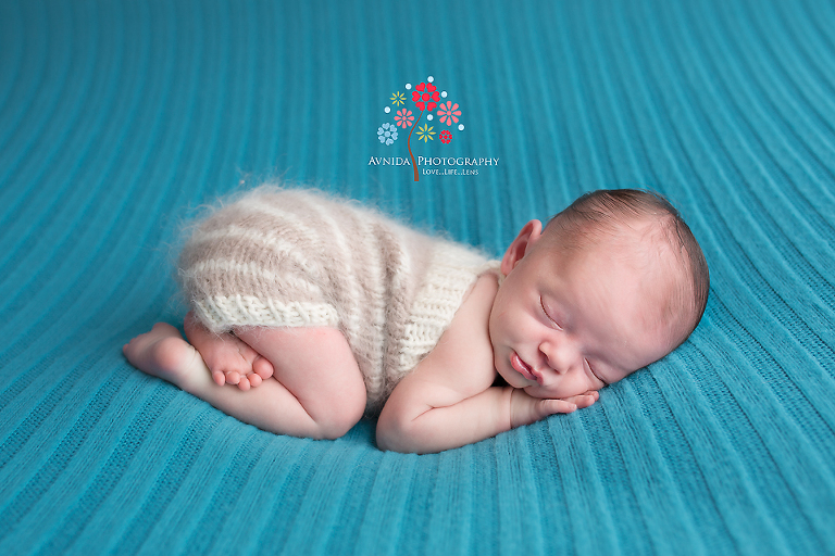 Newborn Photography Milford NJ - A little pout and the right posture makes a big difference - of course the teal blue blanket makes it look even better