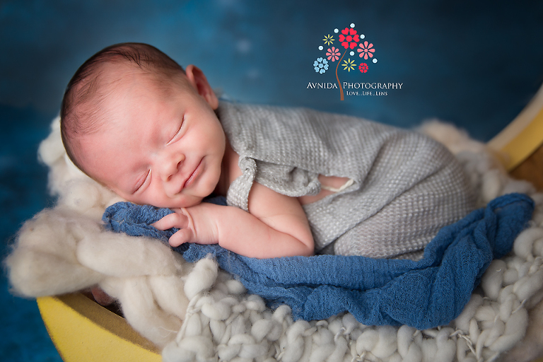 Newborn Photography Milford NJ - Look at that expression - is he trying to hide that smile, sleeping peacefully or playing coy with us - tough to tell with this cutie pie