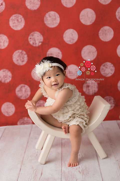 Cake Smash Photography Haworth NJ - A little tilt to the side, hint of a smile, a ruffled romper and cute little feet - we have the start of an awesome cake smash session