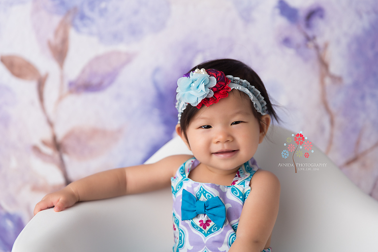 Cake Smash Photography Haworth NJ - This is what we do special, at Avnida Photography, for our little customers - Look at the flower on her headband and how it matches the colors on her dress.