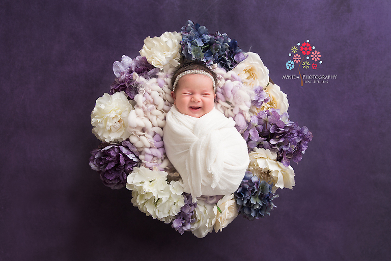 Newborn Photography Spring Lake NJ - This is probably one of the most favorite newborn photographs of all time - I love the colors, the dark lavender background, the flowers and most of all, the excited smile