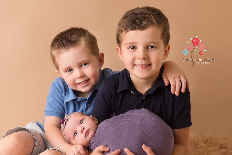 Newborn Photography Rumson NJ - Two cute, shiny eyed brothers completely in love with their cute baby sister, isn't this a wonderful sight