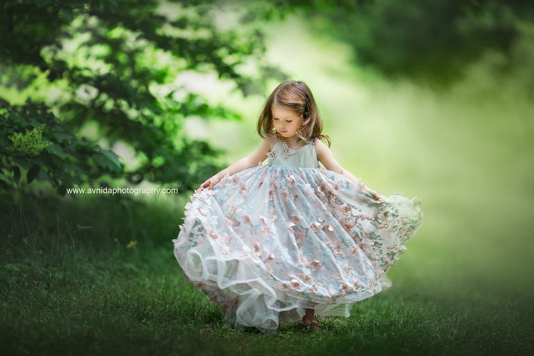 children's couture photography, The little princess twirls in the park, happy about her dress and the opportunity to play around.