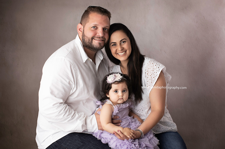 Clearly no smiles here either. Well, we don't blame her at all. With the cake in plain sight in the background, how can the little one give us smiles?