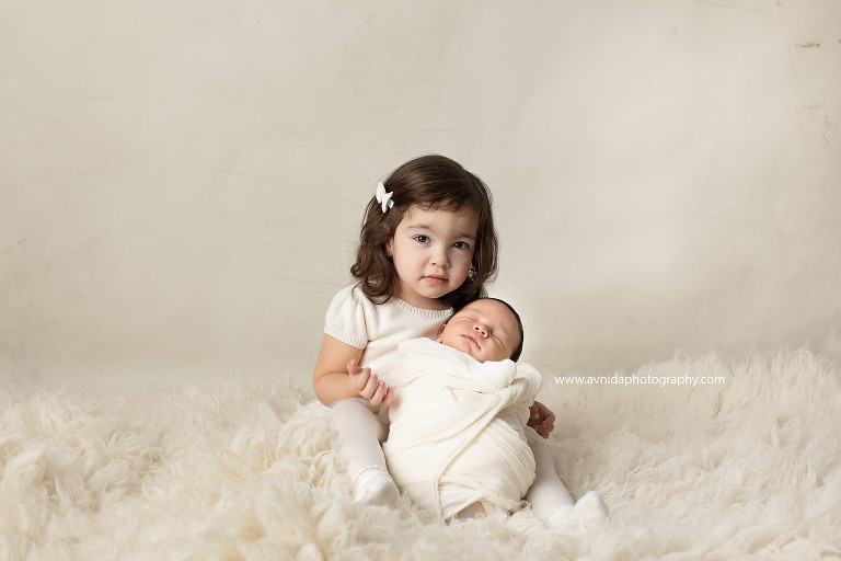 Newborn Photography East Hanover NJ - Baby Daniels enjoying a little nap in the arms of his older sister - best friends forever